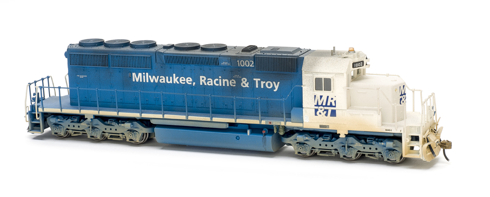 Photo of blue-and-white six-axle road locomotive on white background