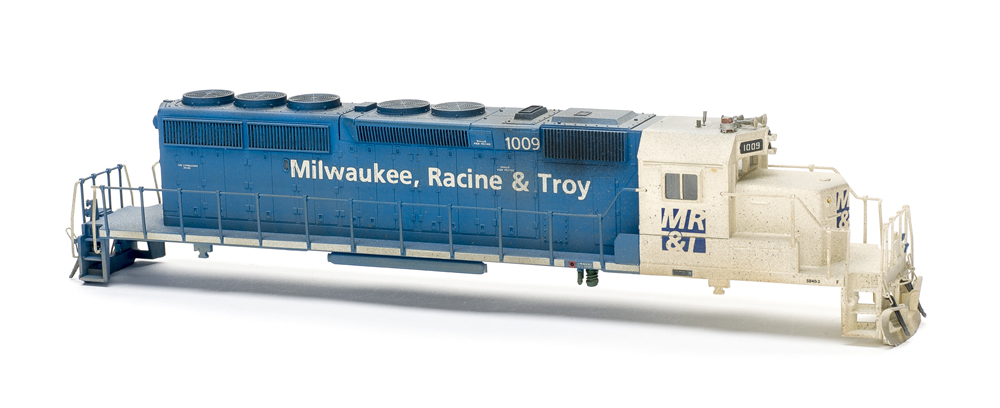 Photo of HO scale locomotive body shell painted blue and white on white background.