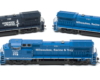 Photo of three HO scale diesel locomotives in various paint schemes on white background
