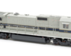 Photo of gray, blue, and orange HO scale locomotive on white background