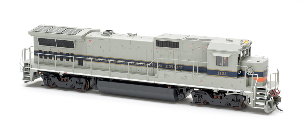 Photo of gray, blue, and orange HO scale locomotive on white background
