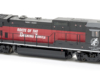 Photo of red and black HO scale locomotive on white background