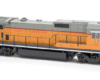 Photo of orange, gray, and red HO scale locomotive on white background