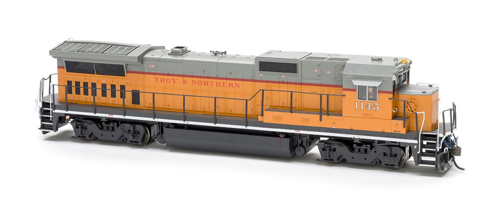Photo of orange, gray, and red HO scale locomotive on white background