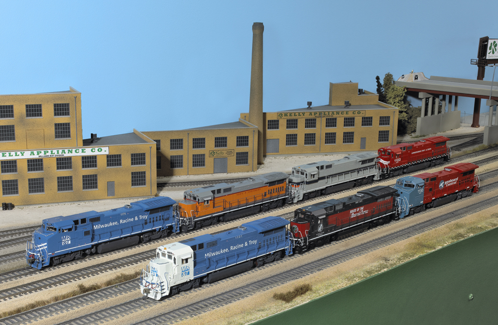 Photo of seven HO scale diesel locomotives on scenicked model railroad