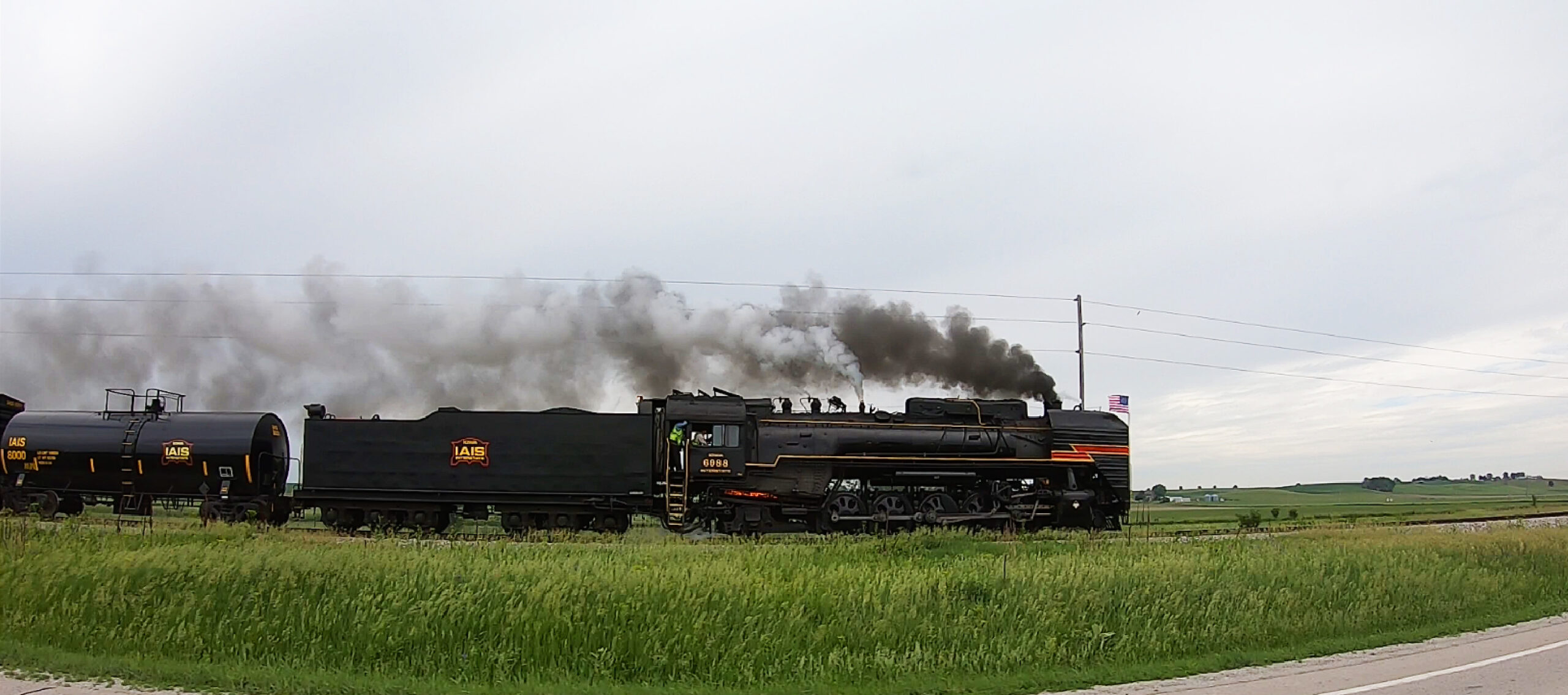 black Chinese built steam locomotive racing across farmland