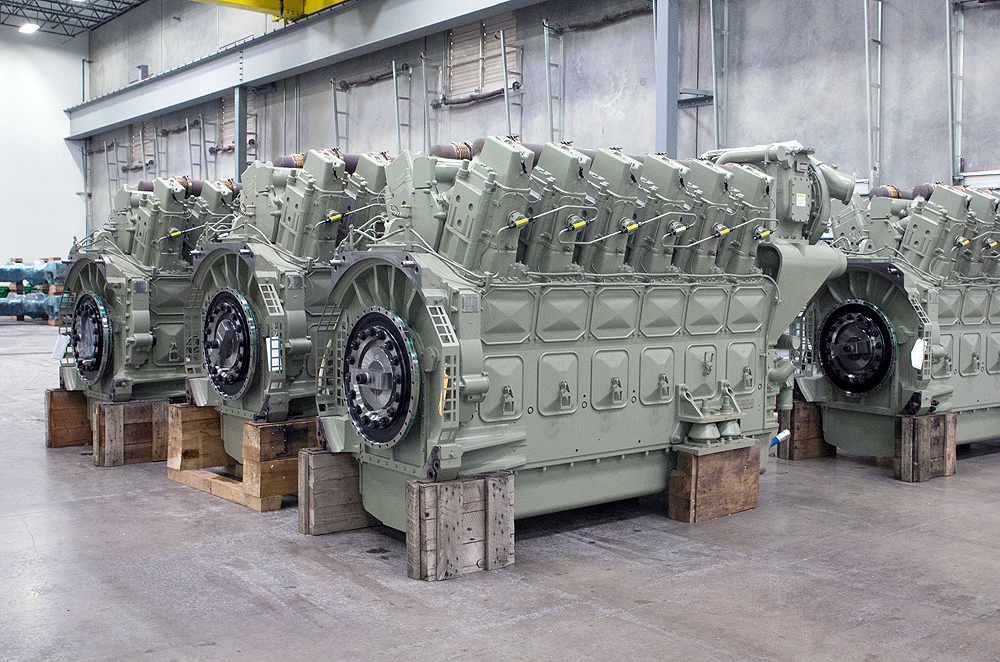 Locomotive prime movers: Pale-green painted engines sit on blocks in a factory.