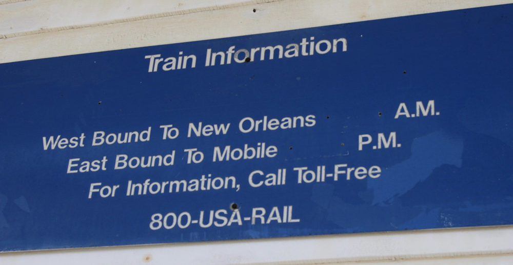 Blue station sign with white lettering of train information