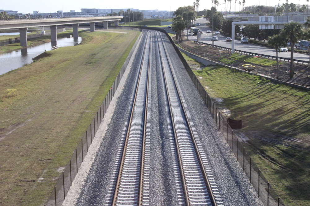 Double-tracked railroad mainline next to roadway