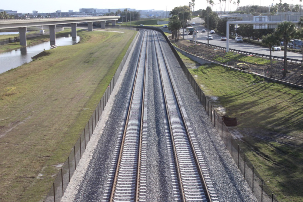 Double-tracked railroad mainline next to roadway