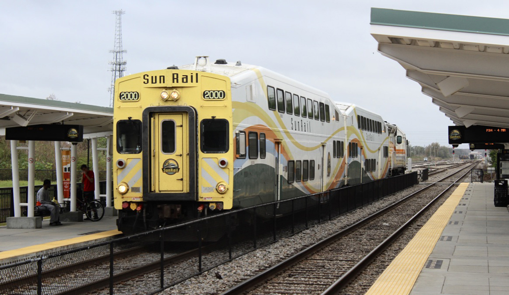 Two-car commuter train with cab car leading arrives at station