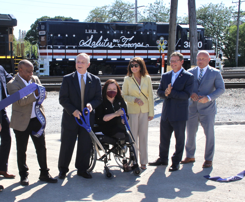 Six people with red, white, and blue locomotive in background