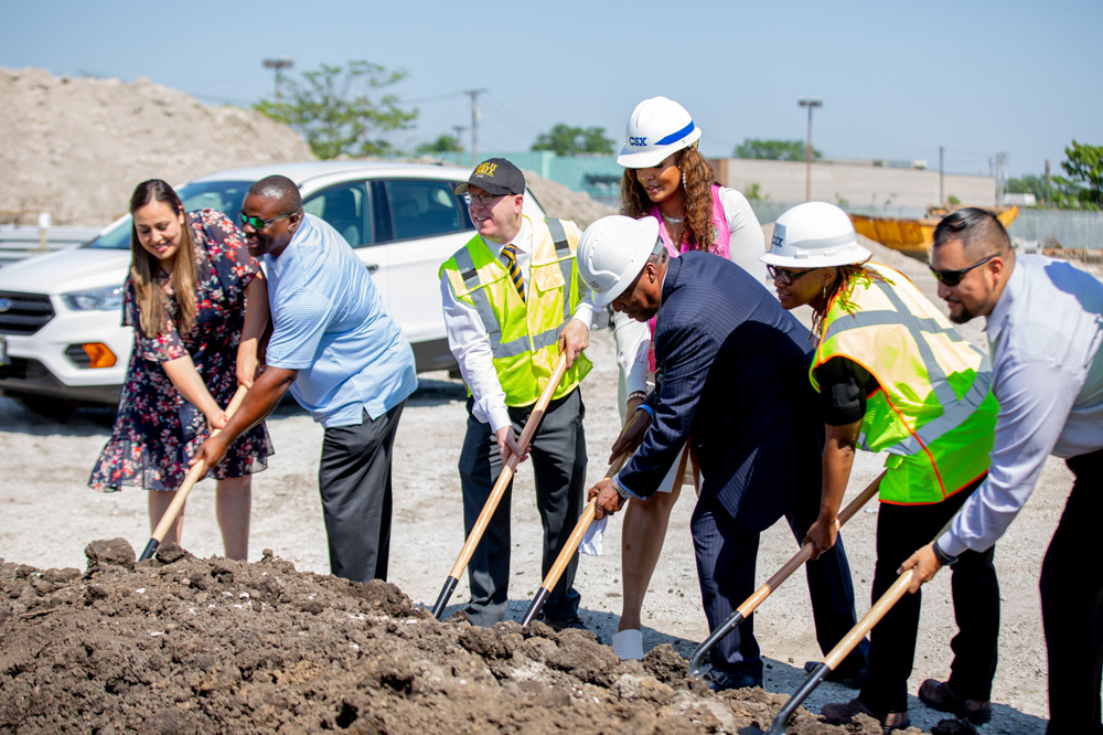 Seven people share shovels in groundbreaking ceremony