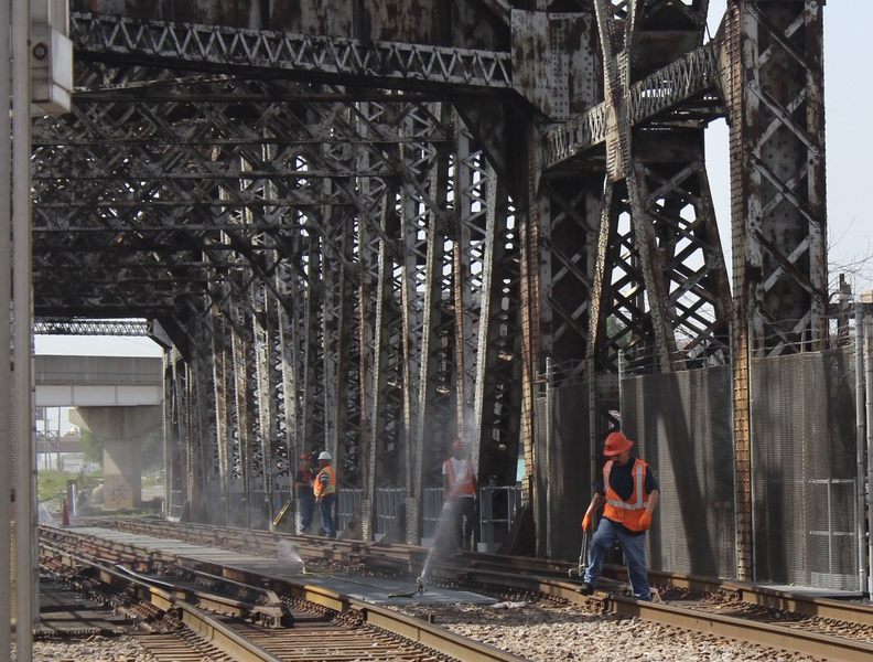 Workers in high-visibility clothing on bridge