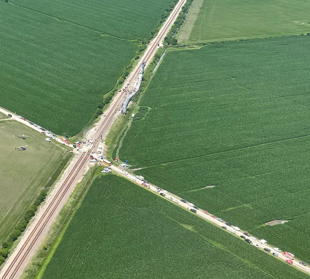 Aerial view of railroad track, road, and green fields