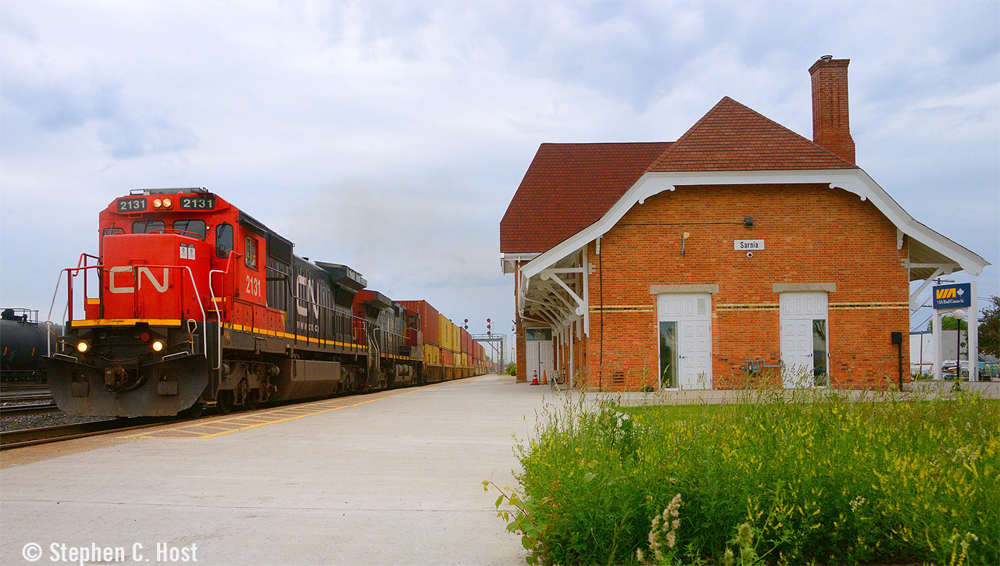 Freight train passing brick passenger station