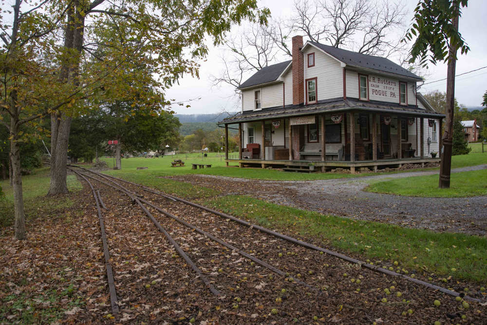 Railroad tracks with wooden house in background