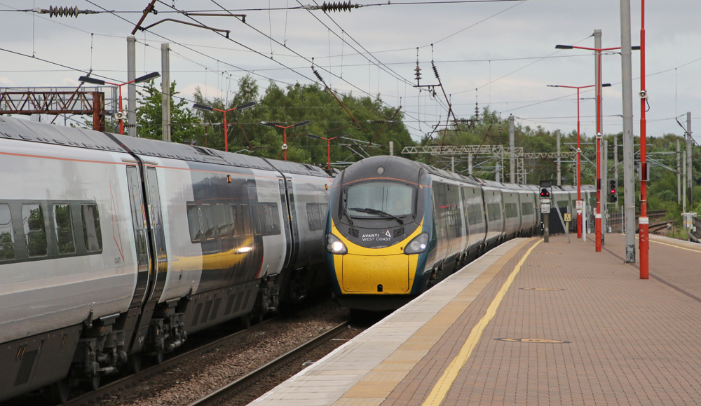 Passenger trains meet next to station platform