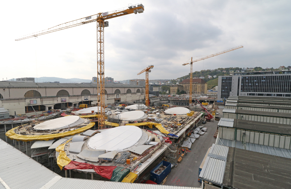 Large construction project with three cranes towering over site