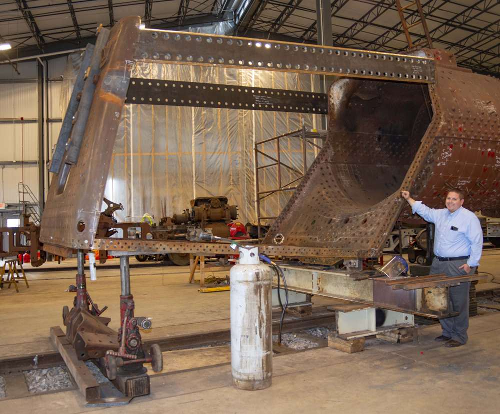 Man standing next to locomotive firebox under development