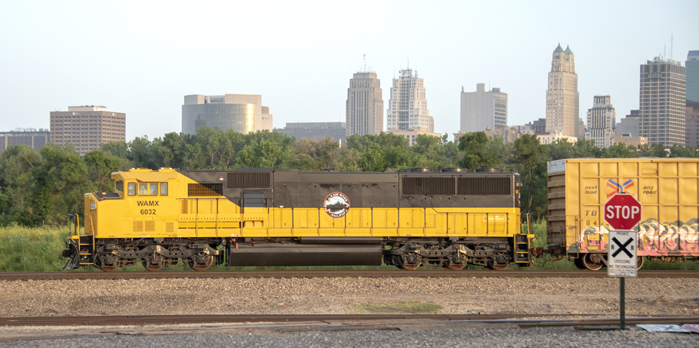 Black and yellow locomotive with city skyline in the background