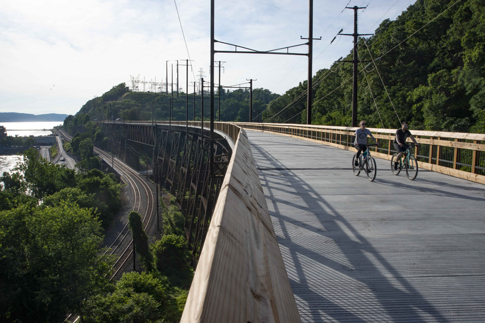 Two bicyclists cross bridge
