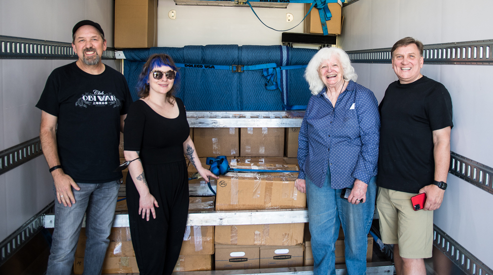 Four people with boxes in truck