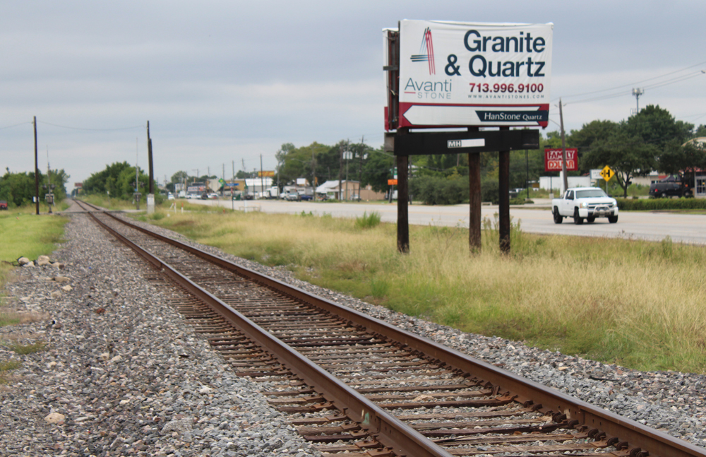 Straight railroad line parallels roadway