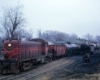 Maroon and red diesel locomotive with freight cars