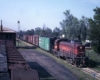 Maroon and red diesel locomotive with boxcars