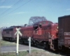 Maroon and red diesel locomotives in grade crossing