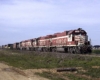 Red and white diesel locomotives with freight train