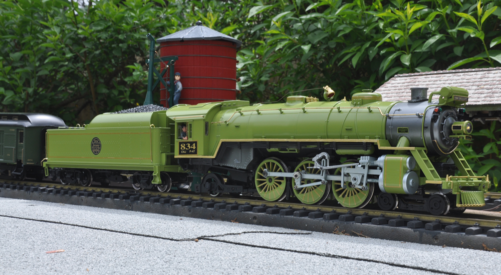 green and black model steam engine on track