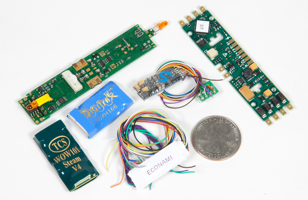 A collection of compact DCC sound decoders on a white background