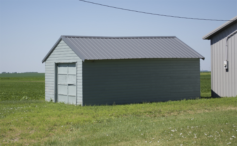 Small gray shed next to farm field