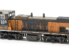 Photo of heavily weathered HO scale end-cab locomotive on white background.