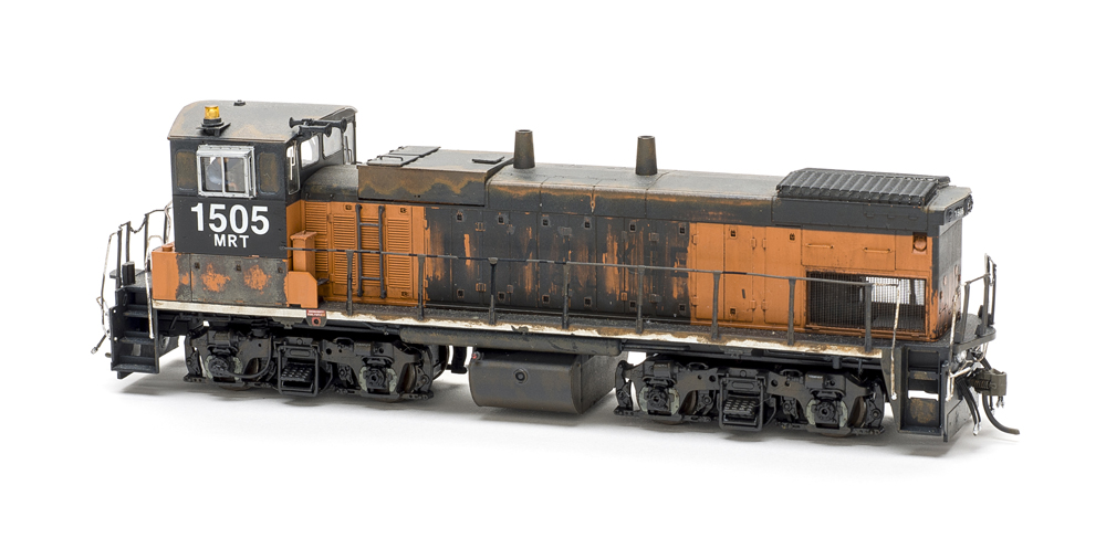 Photo of heavily weathered HO scale end-cab locomotive on white background.