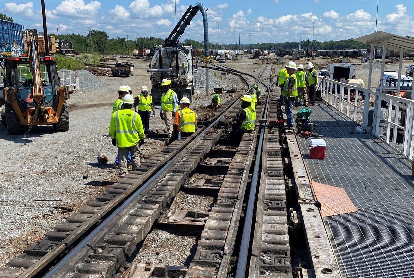 Workers in high-visibility clothingwork on railroad track