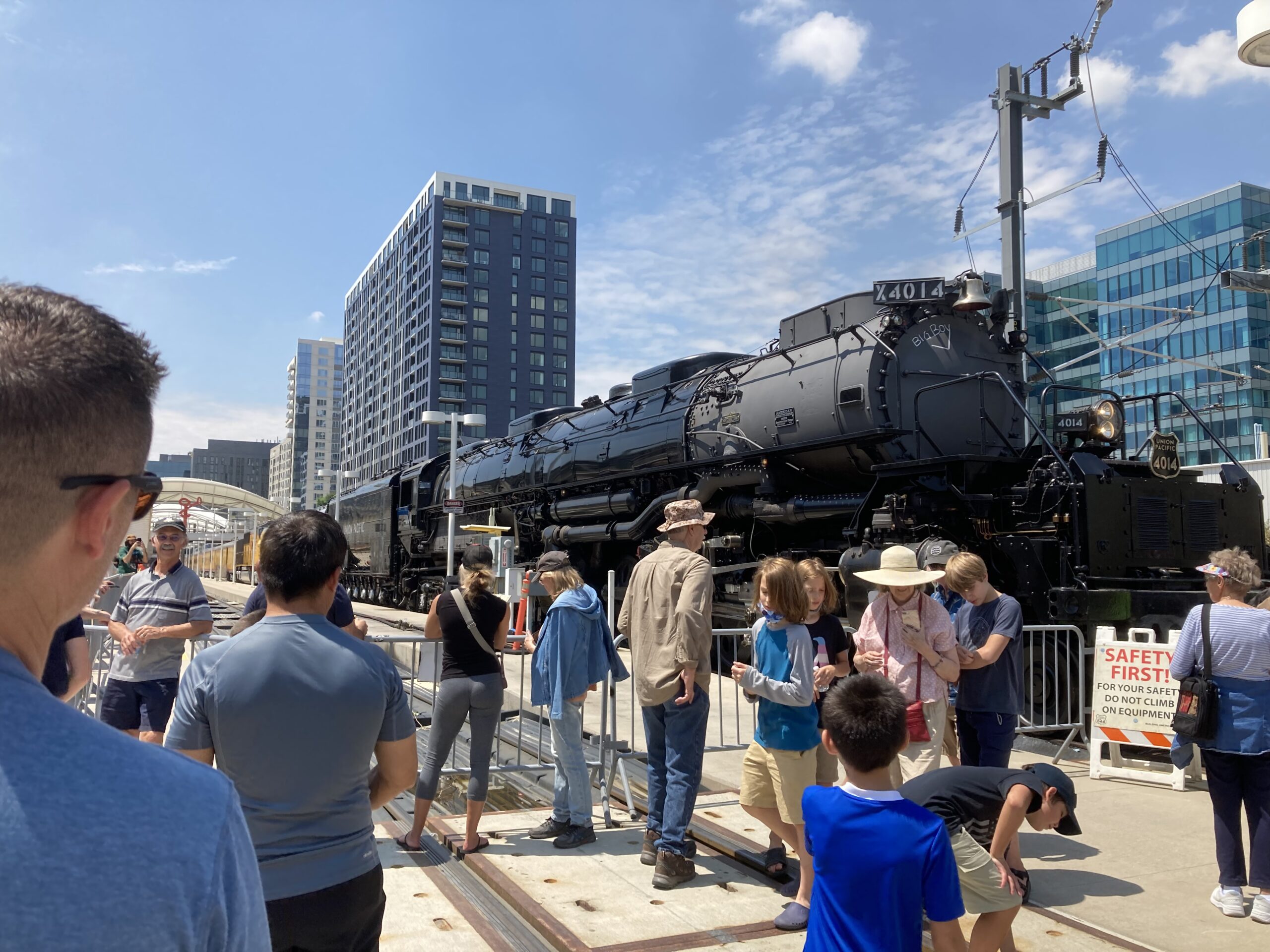 Large black steam locomotive in crowd of people
