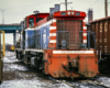 Red-white-and-blue switching locomotive at work in a rail yard.