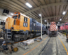 Wide-angle view of locomotives in an engine house.