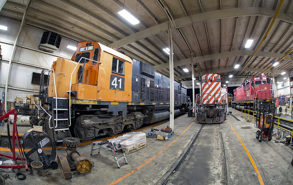 Wide-angle view of locomotives in an engine house.