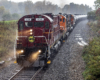 Locomotive leading a train in a downpour of rain.