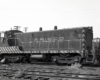 Black-and-white image of an end-cab switcher in a rail yard.