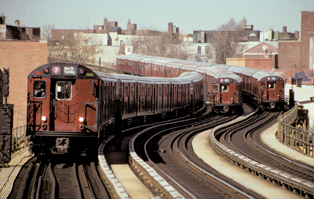 Three trains of red subway cars meet