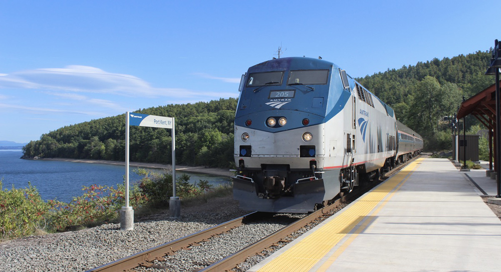 Passenger train at station next to body of water