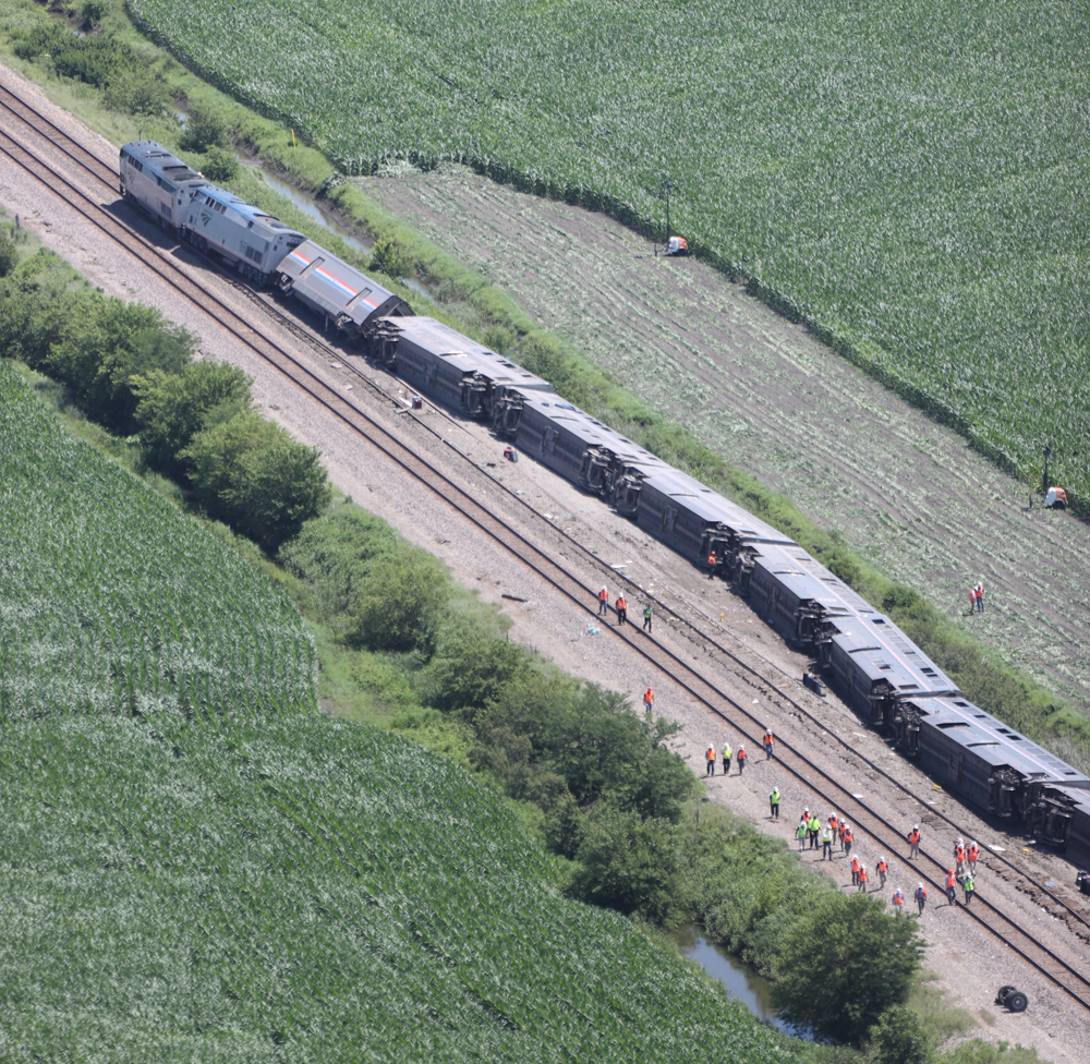 Aerial view of derailed train with cars on their sides