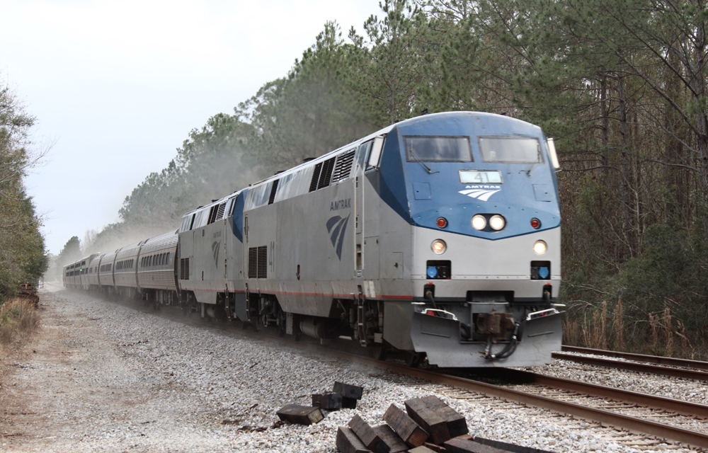 Passneger train kicks up dust from fresh ballast