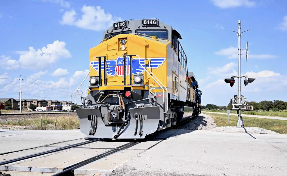 Yellow locomotive at grade crossing