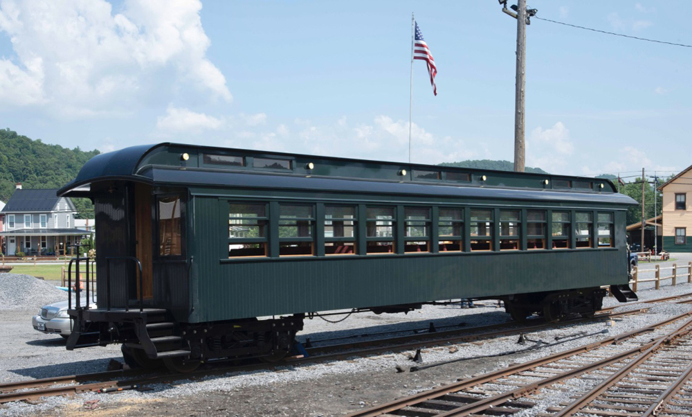 Dark green passenger car on yard track